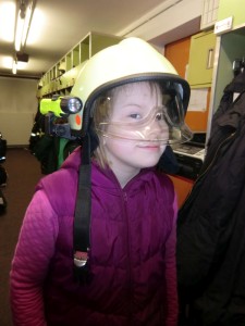 Anna trägt einen Feuerwehrhelm