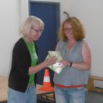 Frau Unger überreicht Frau Meier den Schuljahresbegleiter