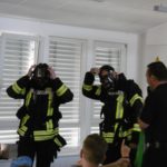 Die Feuerwehrmänner setzen ihr Atemschutzgerät auf.